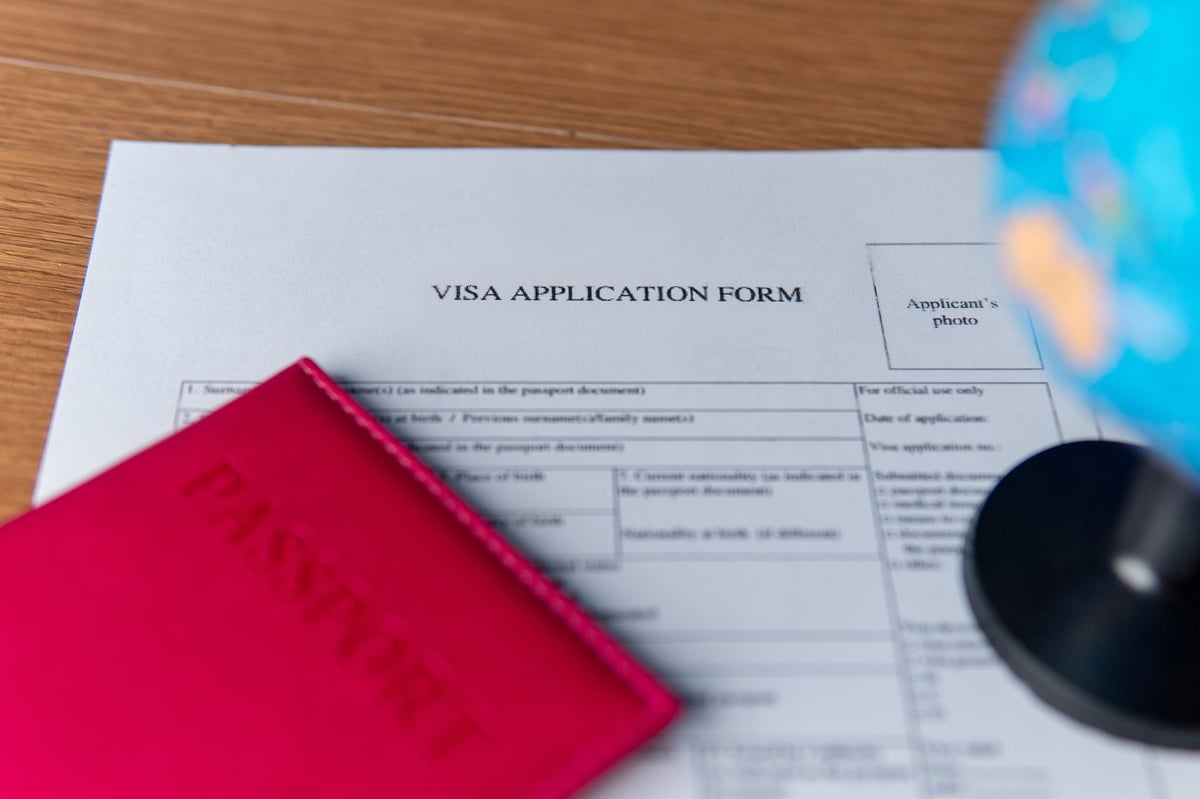 Formulario de solicitud de visa americana 2026 con pasaporte y globo terráqueo representando viajes internacionales