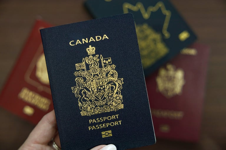 A hand holding a navy blue Canadian passport
