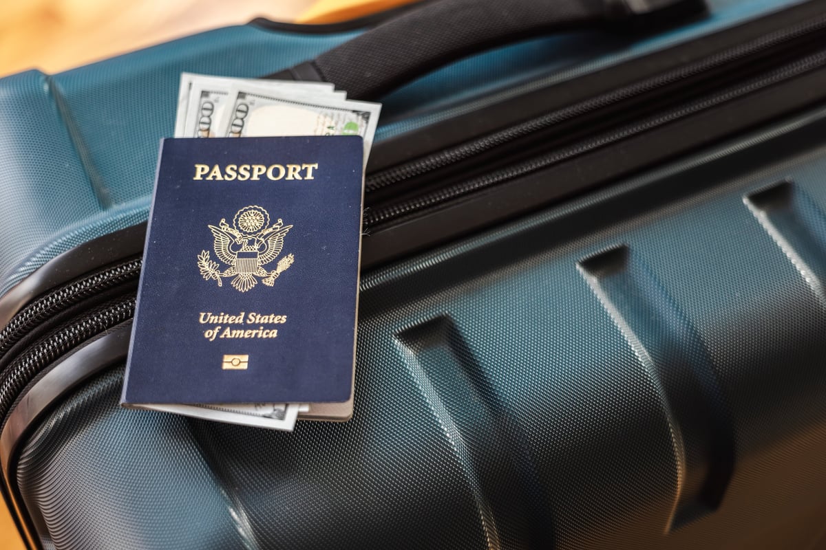 Pasaporte americano con billetes de dólar representando el aumento de tarifa de visa 2026 y la Visa Integrity Fee